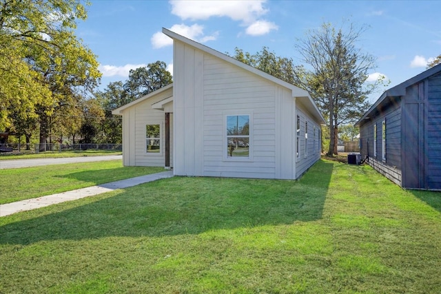 rear view of house featuring a yard and central AC