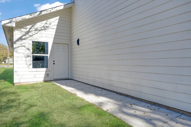 view of exterior entry with a yard