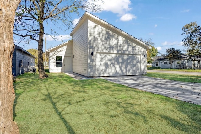 back of house featuring a garage and a lawn