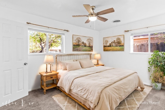 carpeted bedroom featuring baseboards, visible vents, and a ceiling fan