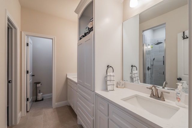 bathroom featuring tile patterned floors, vanity, and a shower with shower door