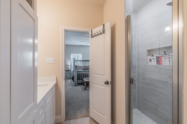 bathroom with tile patterned floors, a shower with door, and vanity