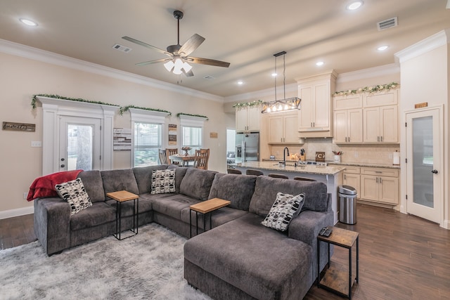 living room featuring ceiling fan, ornamental molding, and dark wood-type flooring