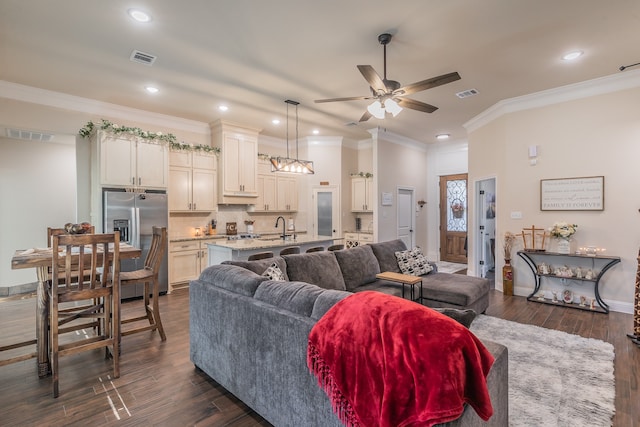 living room with dark hardwood / wood-style flooring, ceiling fan, ornamental molding, and sink