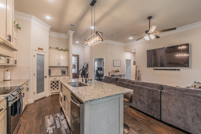 kitchen with stainless steel appliances, dark wood-type flooring, sink, pendant lighting, and a center island with sink