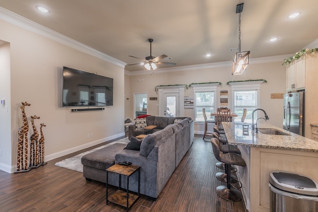 living room with ornamental molding, ceiling fan, dark wood-type flooring, and sink