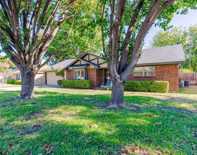 view of front of property with central AC, a front yard, and a garage