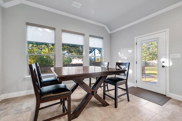 dining area with light tile patterned flooring, lofted ceiling, and ornamental molding