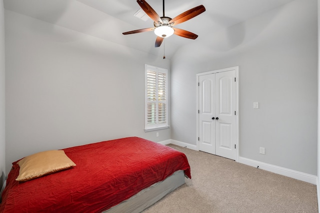 carpeted bedroom featuring ceiling fan, a closet, and vaulted ceiling