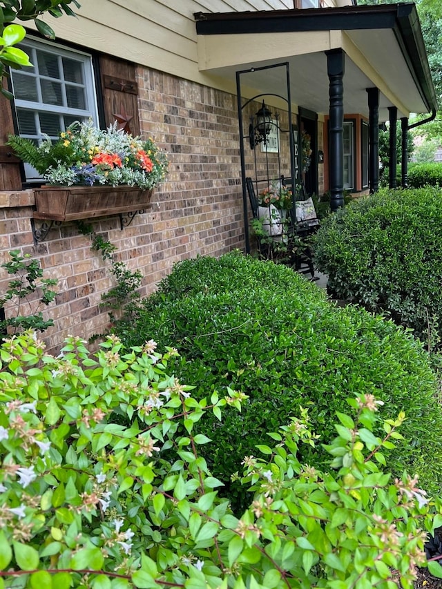 208 Cedar Ln, Burleson, TX 76028 - view of exterior entry with brick siding and a porch