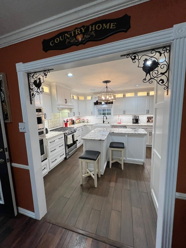 208 Cedar Ln, Burleson, TX 76028 - kitchen featuring gas range, a center island, white cabinetry, dark wood-style floors, and glass insert cabinets