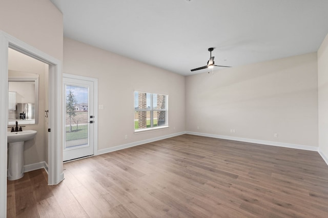 interior space featuring hardwood / wood-style flooring, ceiling fan, and sink