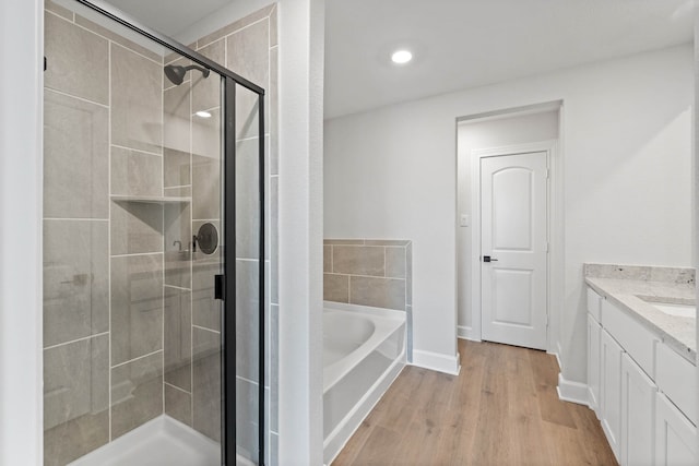 bathroom with vanity, independent shower and bath, and hardwood / wood-style flooring