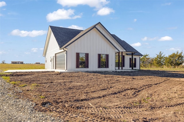 view of front facade featuring roof with shingles and board and batten siding