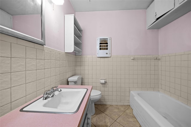 bathroom featuring vanity, tile patterned floors, a bathing tub, toilet, and tile walls