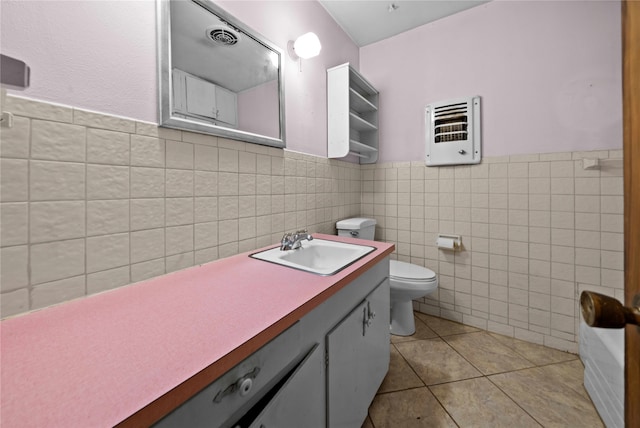 bathroom with vanity, tile patterned flooring, toilet, tile walls, and heating unit