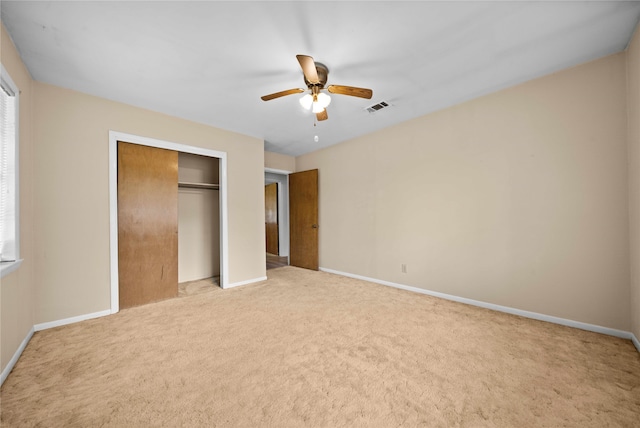 unfurnished bedroom featuring ceiling fan, a closet, and light carpet