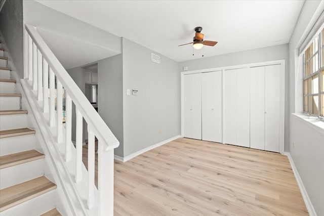 interior space with light hardwood / wood-style flooring, ceiling fan, and multiple closets