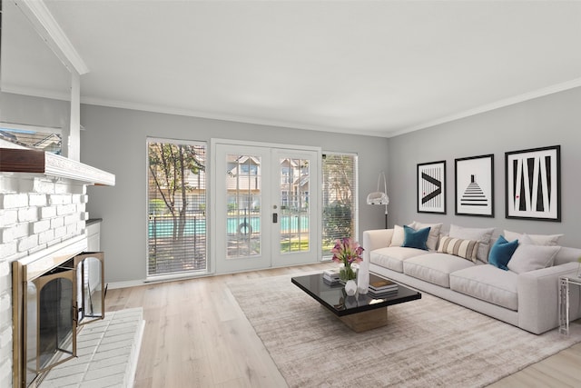 living room featuring a fireplace, ornamental molding, and light hardwood / wood-style flooring