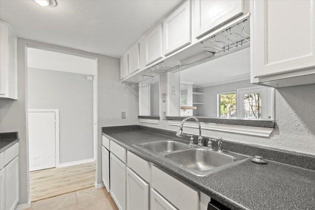 kitchen featuring sink, white cabinets, and light wood-type flooring