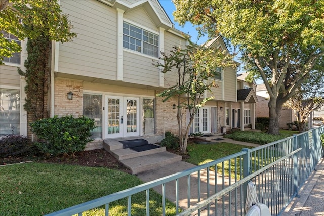 view of front of property with french doors and a front lawn