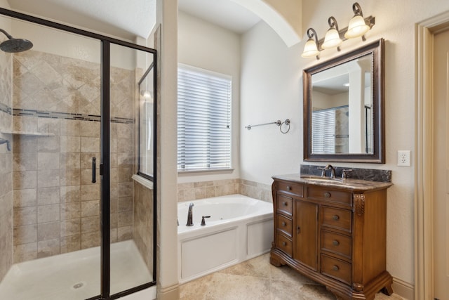 bathroom with a stall shower, tile patterned floors, a garden tub, and vanity