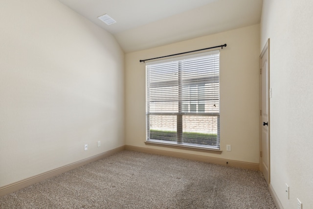 spare room with lofted ceiling, visible vents, light carpet, and baseboards