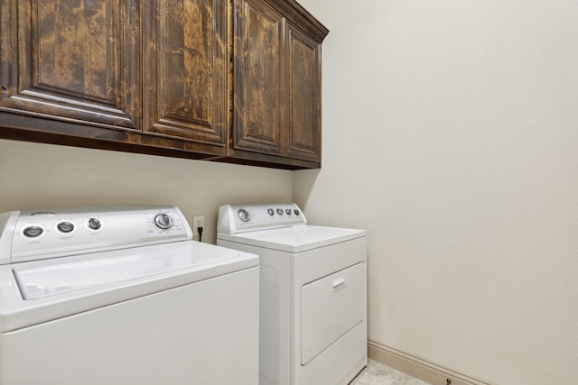 laundry area with cabinet space, washing machine and dryer, and baseboards