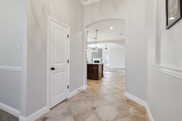 hallway featuring arched walkways, light tile patterned floors, recessed lighting, and baseboards