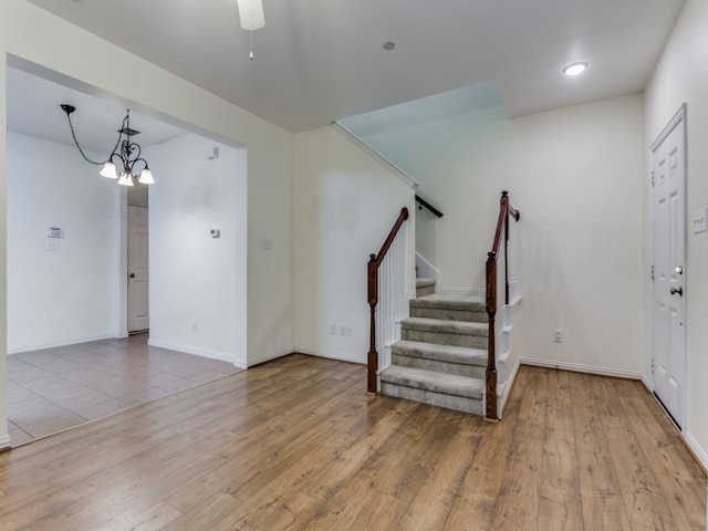 foyer entrance with light hardwood / wood-style flooring and a chandelier