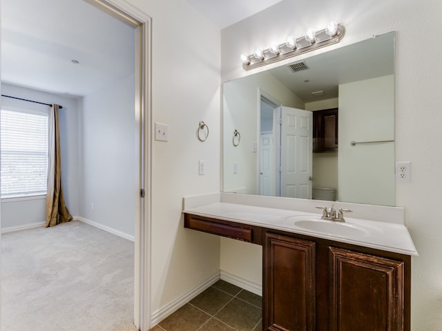 bathroom featuring tile patterned flooring, vanity, and toilet