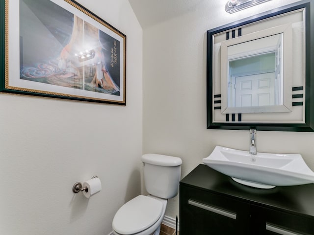 bathroom with vanity, toilet, and lofted ceiling