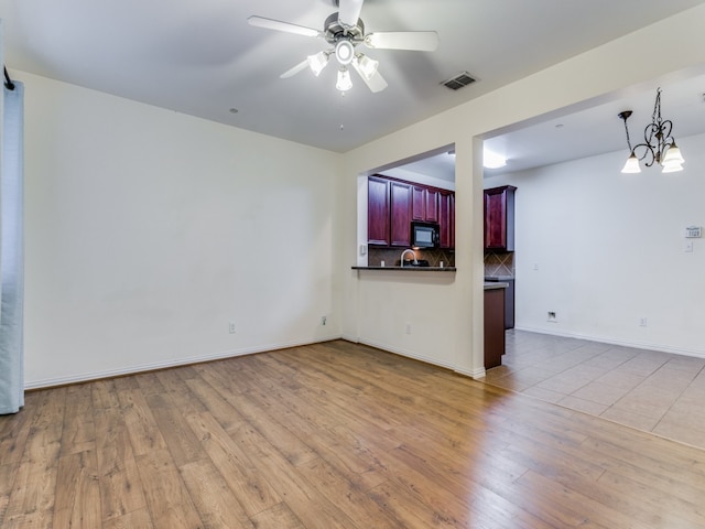 unfurnished living room featuring ceiling fan and light wood-type flooring