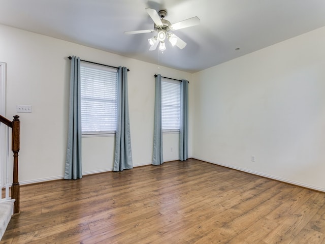 empty room with ceiling fan, plenty of natural light, and light wood-type flooring