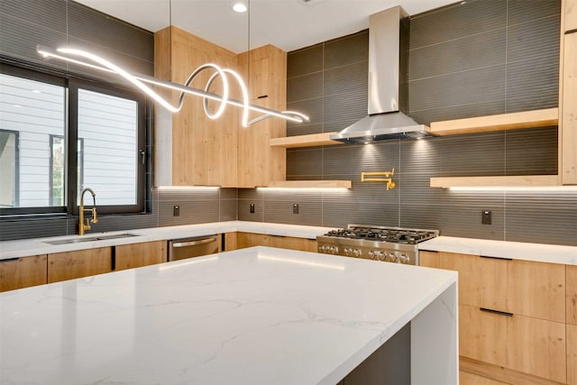 kitchen with light stone countertops, decorative backsplash, wall chimney exhaust hood, sink, and pendant lighting