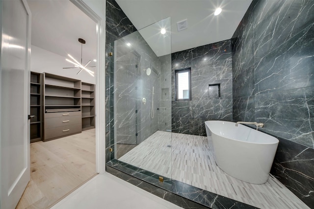 bathroom featuring separate shower and tub, hardwood / wood-style floors, a chandelier, and tile walls