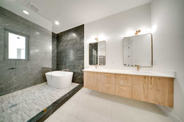 bathroom featuring vanity, a tub to relax in, tile patterned floors, and tile walls