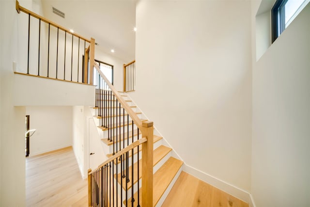 staircase with hardwood / wood-style floors and a healthy amount of sunlight