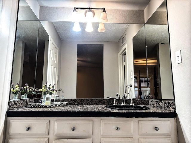 bathroom with a textured ceiling and vanity