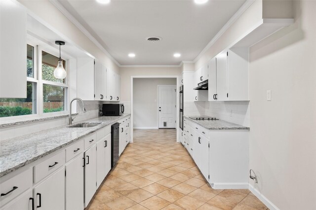 kitchen featuring backsplash, sink, black appliances, pendant lighting, and white cabinets