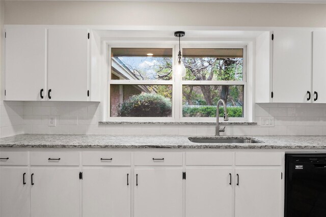 kitchen featuring backsplash, sink, white cabinets, and black dishwasher