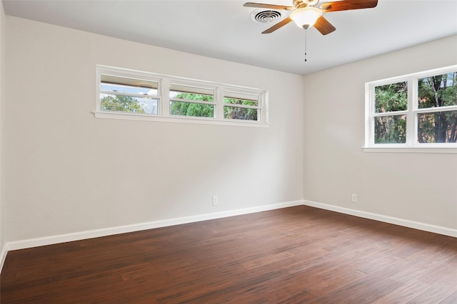 empty room with ceiling fan and dark hardwood / wood-style floors