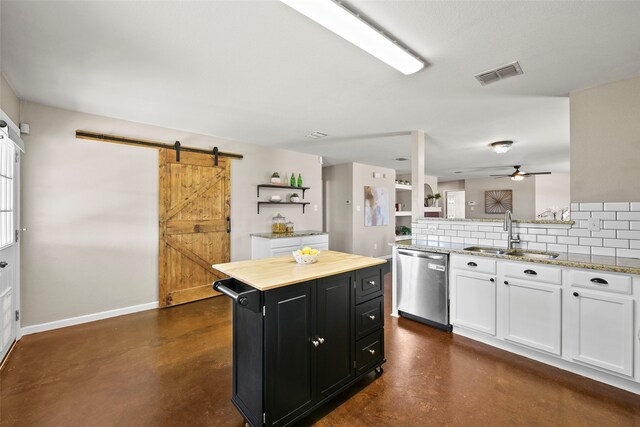 kitchen featuring butcher block countertops, a barn door, a center island, and blue cabinets