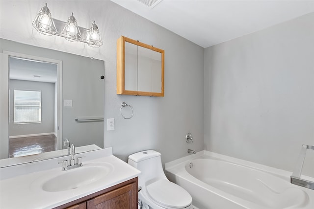 bathroom featuring a washtub, vanity, and toilet