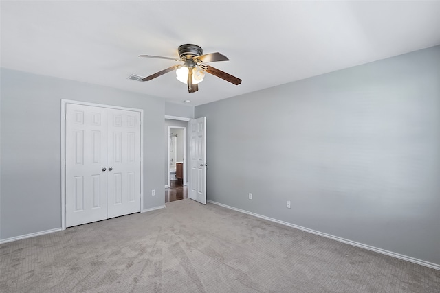 unfurnished bedroom with ceiling fan, a closet, and light colored carpet