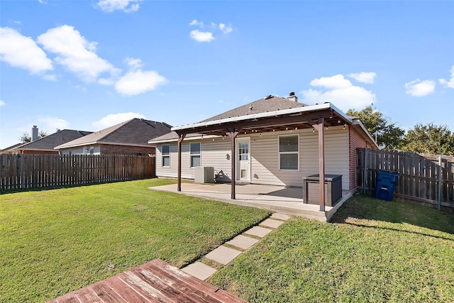 rear view of house with cooling unit, a patio area, and a lawn