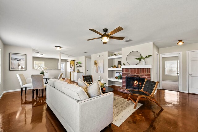 unfurnished living room with a brick fireplace, built in shelves, a textured ceiling, ceiling fan, and a barn door