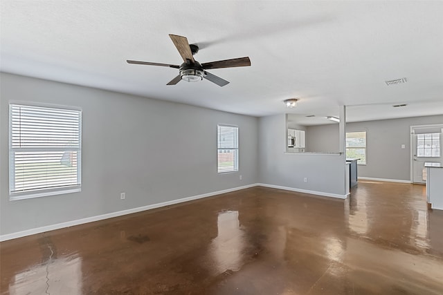 unfurnished living room featuring ceiling fan and a textured ceiling