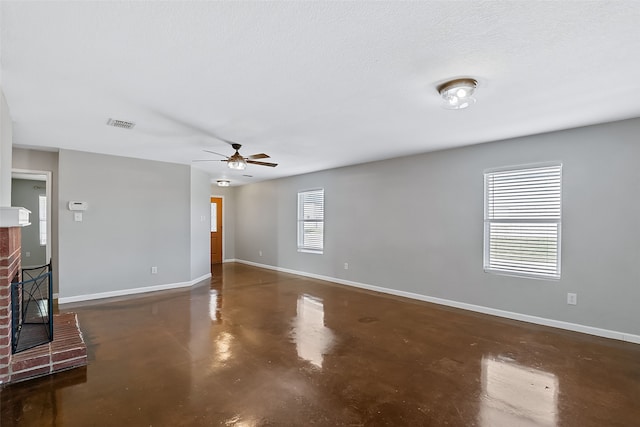 unfurnished living room with a textured ceiling, ceiling fan, and a fireplace