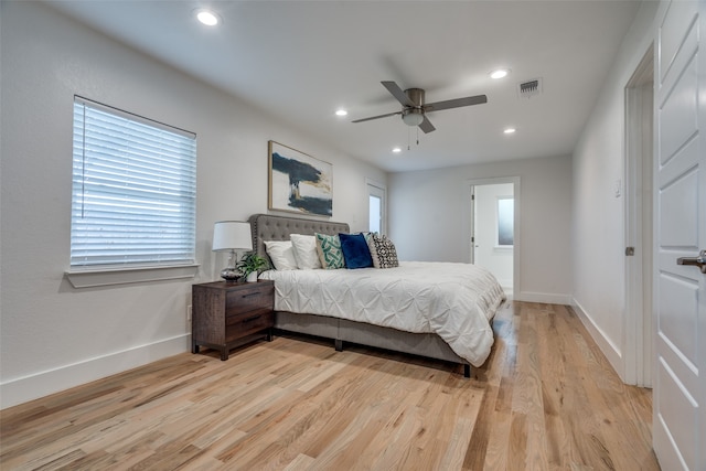 bedroom featuring ensuite bath, ceiling fan, and light wood-type flooring